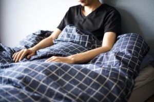 ベッドで悩む男性